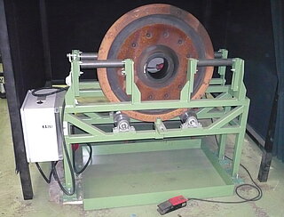 Rollvorrichtung für Einzelrad-MT-Prüfung Rollvorrichtung für Einzelrad-MT-Prüfung (mit aufgesetztem Rad): Die Vorrichtung nimmt dabei die Radscheiben in stehender Lage auf und führt sie seitlich kippstabil während die Radscheiben in eine gleichmäßige Rollbewegung versetzt werden.