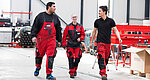 Three MINDA employees walk through a production hall together and talk