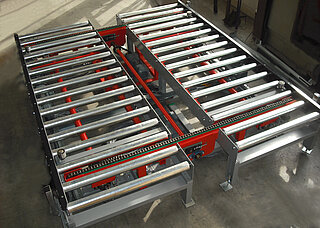 Angular transfer; combination roller conveyor - chain conveyor: The angular transfer consists of two parallel roller conveyors in which a chain conveyor rotated by 90° is integrated.