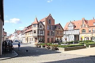 Verschiedene Fachwerkhäuser zieren die Straßen der historischen Innenstadt. Im Zenrum ist ein Hotel mit Gaststätte im mittelalterlichem Flair zu sehen.