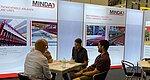 Mitarbeiter von MINDA unterhalten sich an MINDA-Messestand