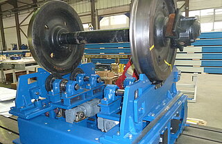 Lifting and rolling device with a wheelset: This device is designed for  adjustable track widths. You can see only the upper part of the device, because this lifting-rolling device will be embedded in a pit on site.