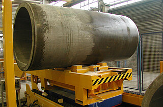 Transport car with horizontally arranged concrete pipes: This transport car, which is equipped with a lifting table, transports the pipes on a fixed transport section to the final processing.