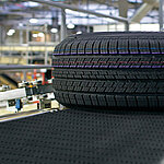 A close-up of a tire lying on a conveyor belt